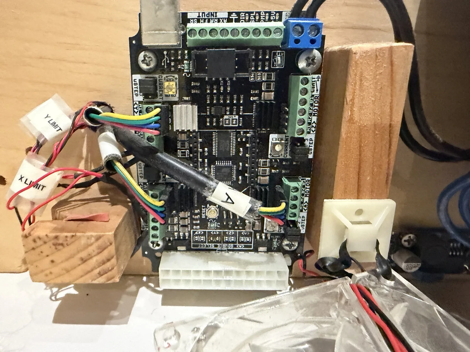 A stepper driver board on a plywood base, its loose leads tagged X LIMIT and Y LIMIT
