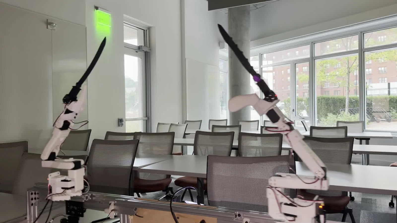 Two real robot arms mid-exchange: an overhead chop caught on the high bar