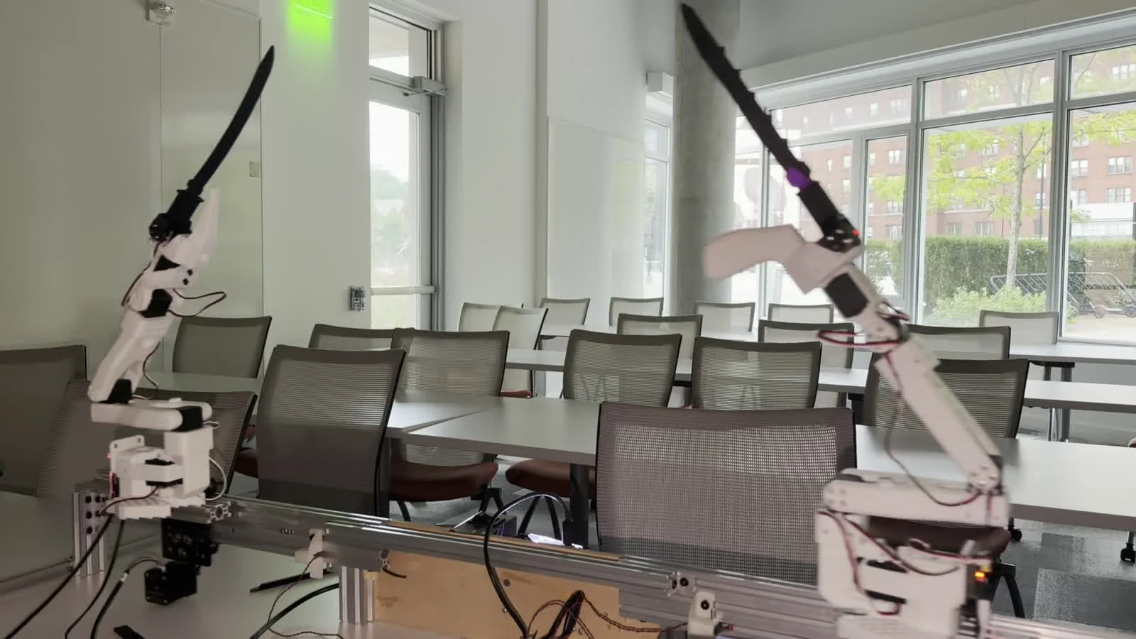 Two real robot arms mid-exchange: an overhead chop coming down against a low guard